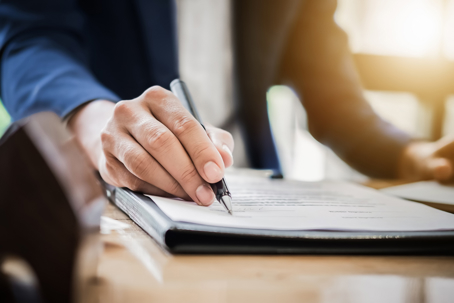 estate agent gives pen and documents agreement with customer to sign contract